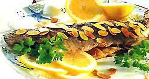 Форель с орехами миндаля и лимоном в духовке фотография